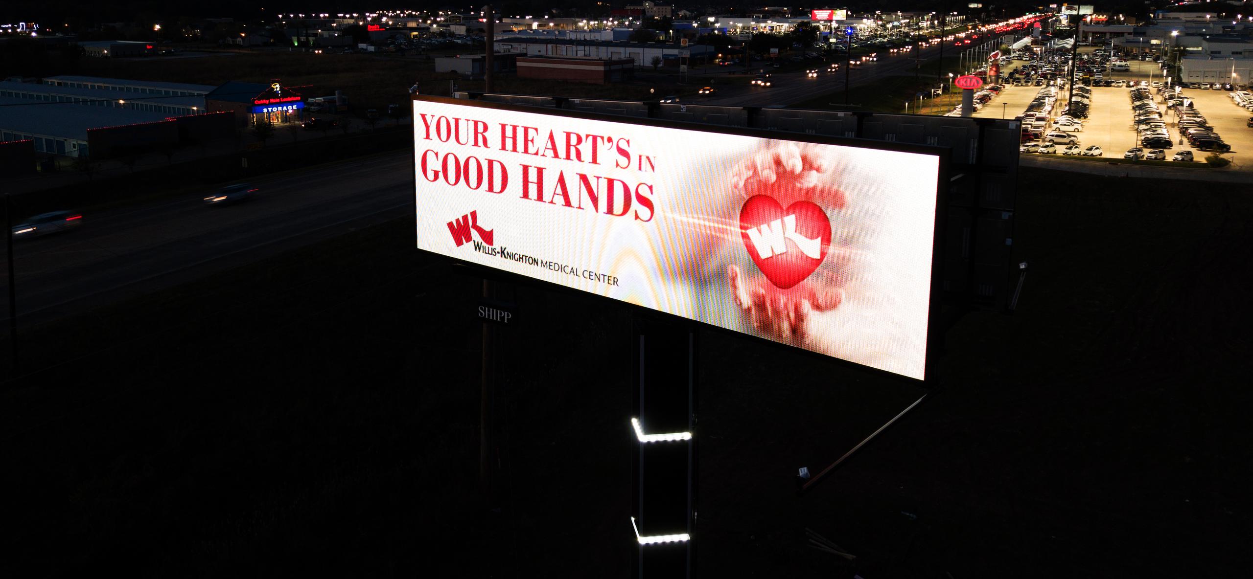 A Shipp Outdoor digital billboard lit at night along the Shreveport Automall